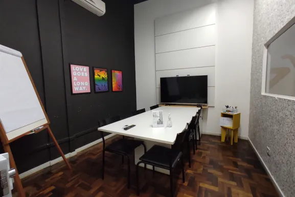 Sala de reunião Talento com mesa, TV e flipchart na Aldeia Cândido de Abreu