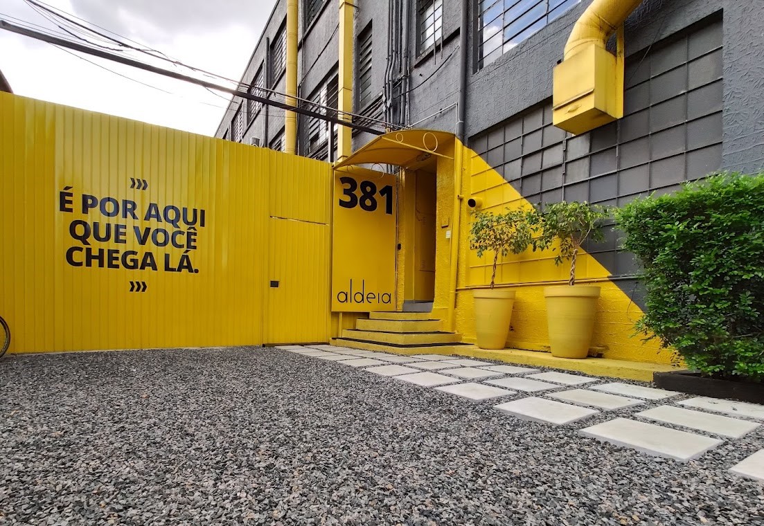 Ambiente de coworking da Aldeia com mesa de trabalho e estrutura profissional