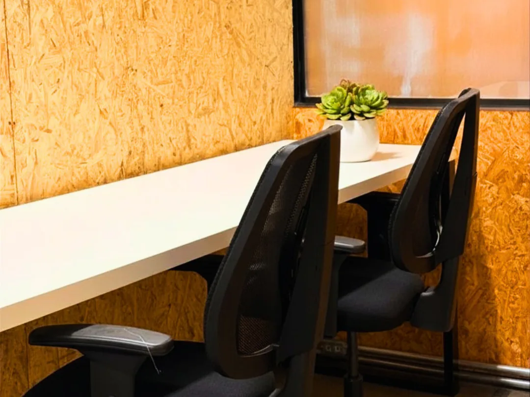 Bancada de trabalho com cadeiras ergonômicas na Aldeia Coworking